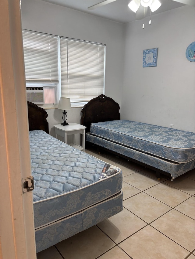 tiled bedroom with ceiling fan and cooling unit