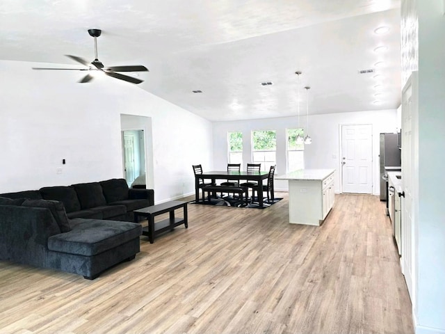 living room with vaulted ceiling, ceiling fan, and light hardwood / wood-style flooring