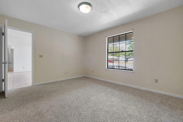 unfurnished room with baseboards and light carpet