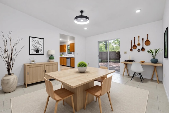 dining space with baseboards, vaulted ceiling, and light tile patterned flooring