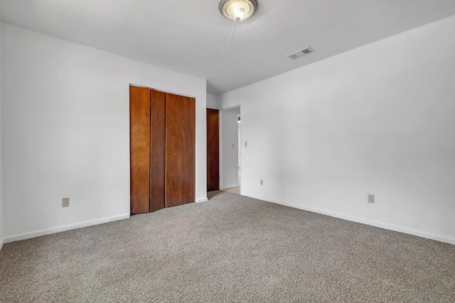unfurnished bedroom with visible vents, carpet, baseboards, and a closet