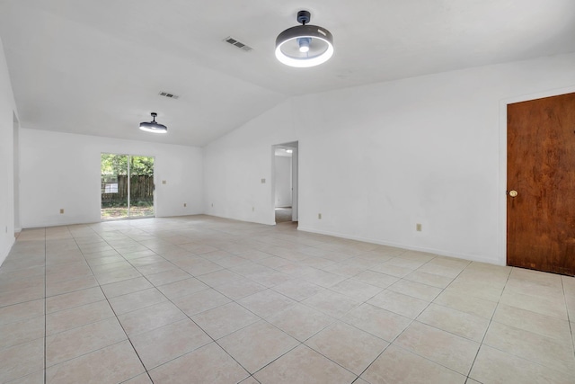 unfurnished room featuring visible vents, lofted ceiling, and light tile patterned flooring