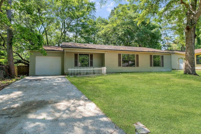 ranch-style home with an attached garage, fence, driveway, and a front yard