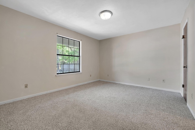 carpeted spare room featuring baseboards