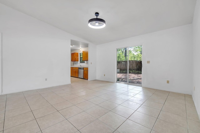 unfurnished room featuring baseboards, vaulted ceiling, and light tile patterned flooring