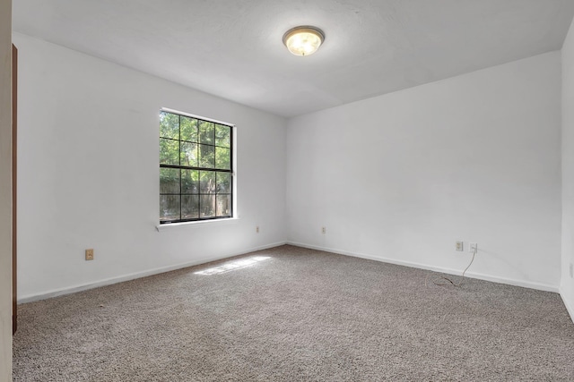 spare room featuring baseboards and carpet