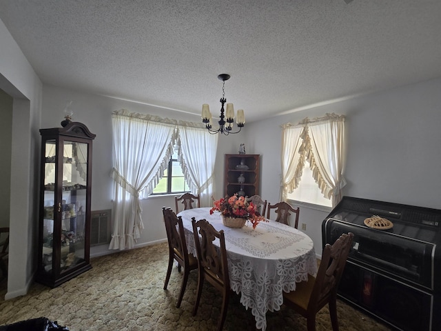 3232 Loren Henderson Rd, Perry, FL 32347 - carpeted dining room featuring a textured ceiling, a notable chandelier, and baseboards