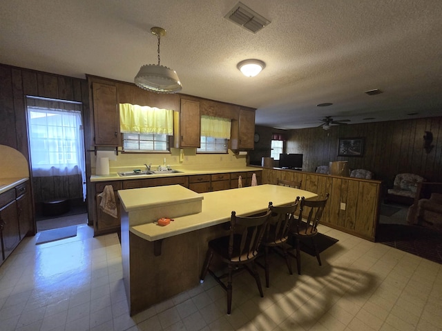 3232 Loren Henderson Rd, Perry, FL 32347 - kitchen with light floors, light countertops, wood walls, a sink, and visible vents