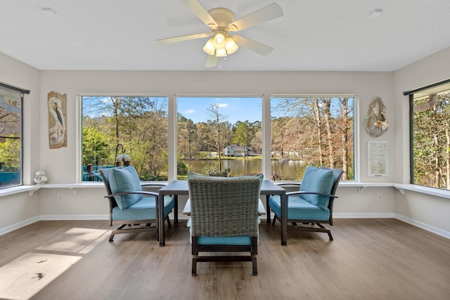 sunroom with plenty of natural light, baseboards, and wood finished floors