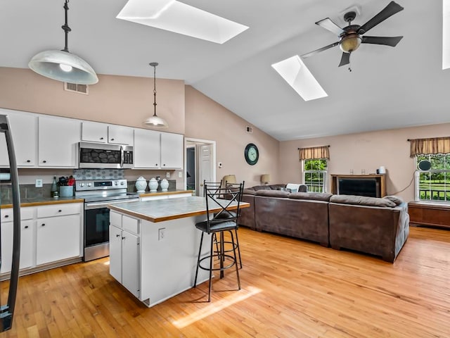 kitchen featuring white cabinets, appliances with stainless steel finishes, and plenty of natural light