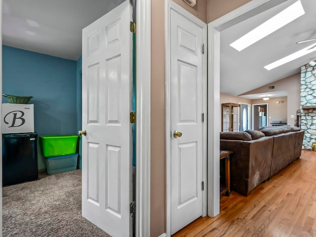 corridor with lofted ceiling and wood-type flooring