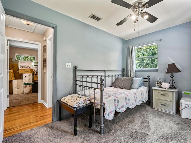 bedroom featuring multiple windows, hardwood / wood-style floors, and ceiling fan