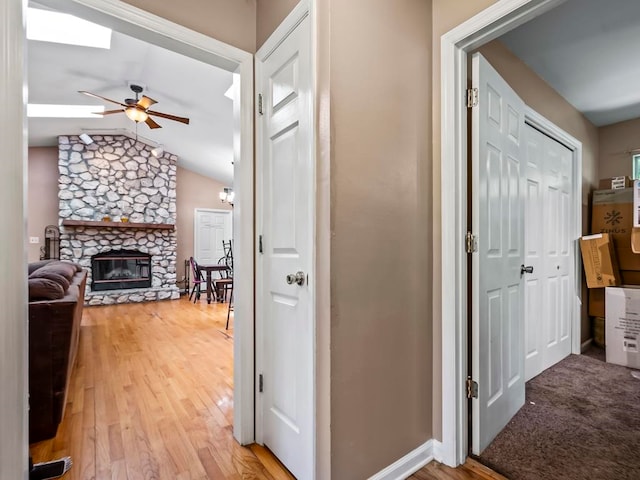 hallway featuring light hardwood / wood-style floors and lofted ceiling