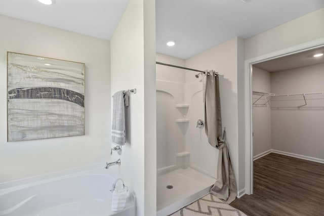 bathroom featuring plus walk in shower and hardwood / wood-style floors