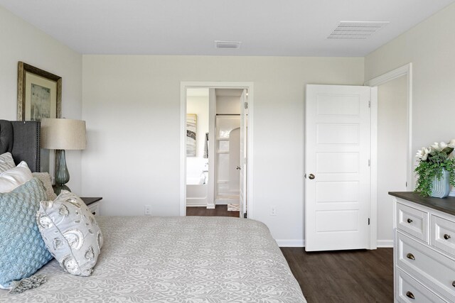 bedroom with dark wood-type flooring and ensuite bath