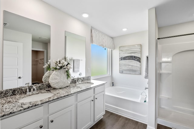 bathroom featuring hardwood / wood-style flooring, vanity, and separate shower and tub