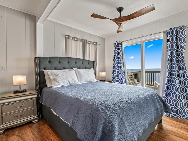 bedroom featuring ceiling fan, a water view, access to exterior, and dark hardwood / wood-style flooring