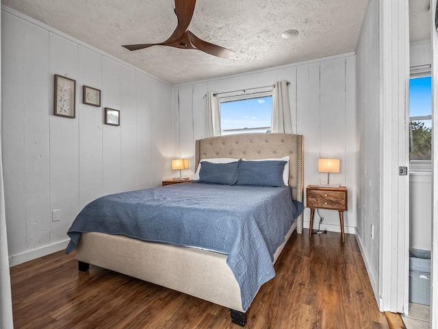 bedroom with ceiling fan, hardwood / wood-style flooring, and a textured ceiling