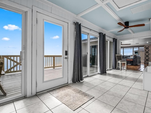 doorway with light tile patterned floors and ceiling fan