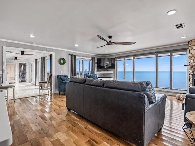 living room featuring crown molding, light hardwood / wood-style flooring, and ceiling fan