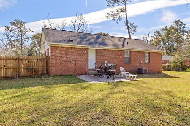 rear view of house with brick siding, a patio area, fence, and a yard