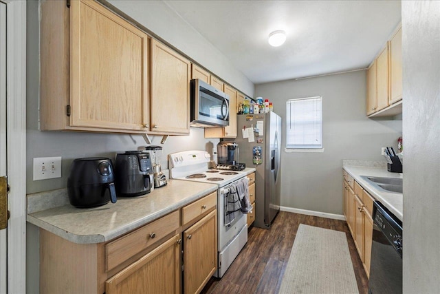 kitchen featuring dark wood finished floors, stainless steel appliances, light countertops, light brown cabinetry, and baseboards