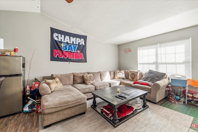 living area with vaulted ceiling and wood finished floors