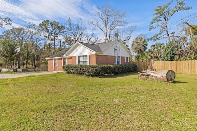 view of home's exterior with fence, a lawn, and brick siding