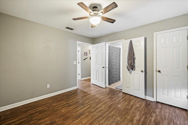 unfurnished bedroom featuring a ceiling fan, baseboards, visible vents, and dark wood-type flooring