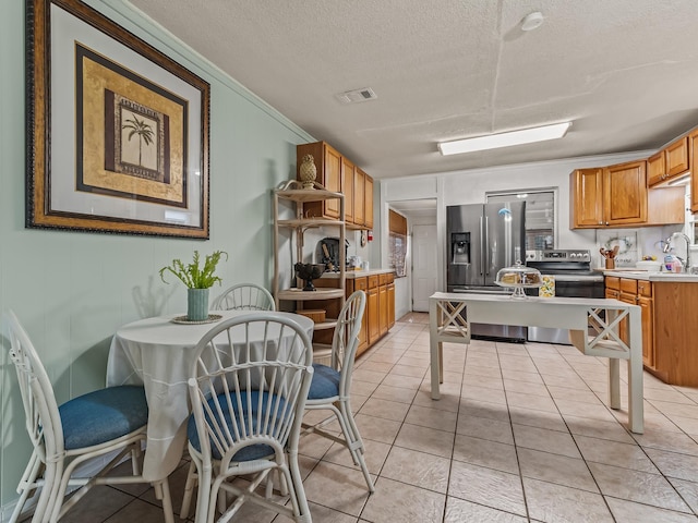 6 Parker Ave Unit 3 & 4, Lanark Village, FL 32323 - kitchen with appliances with stainless steel finishes, a textured ceiling, light countertops, ornamental molding, and light tile patterned floors