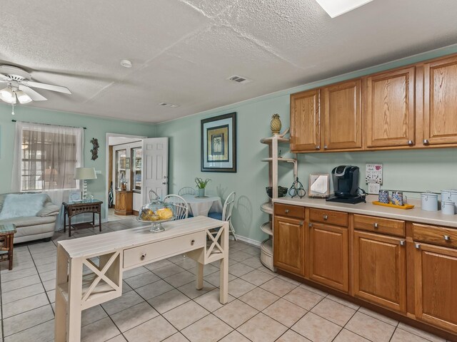 6 Parker Ave Unit 3 & 4, Lanark Village, FL 32323 - kitchen featuring brown cabinets, light tile patterned floors, light countertops, a textured ceiling, and ceiling fan