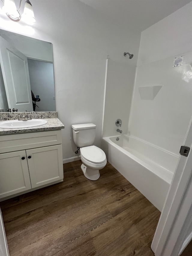 full bathroom featuring toilet, washtub / shower combination, vanity, and hardwood / wood-style flooring