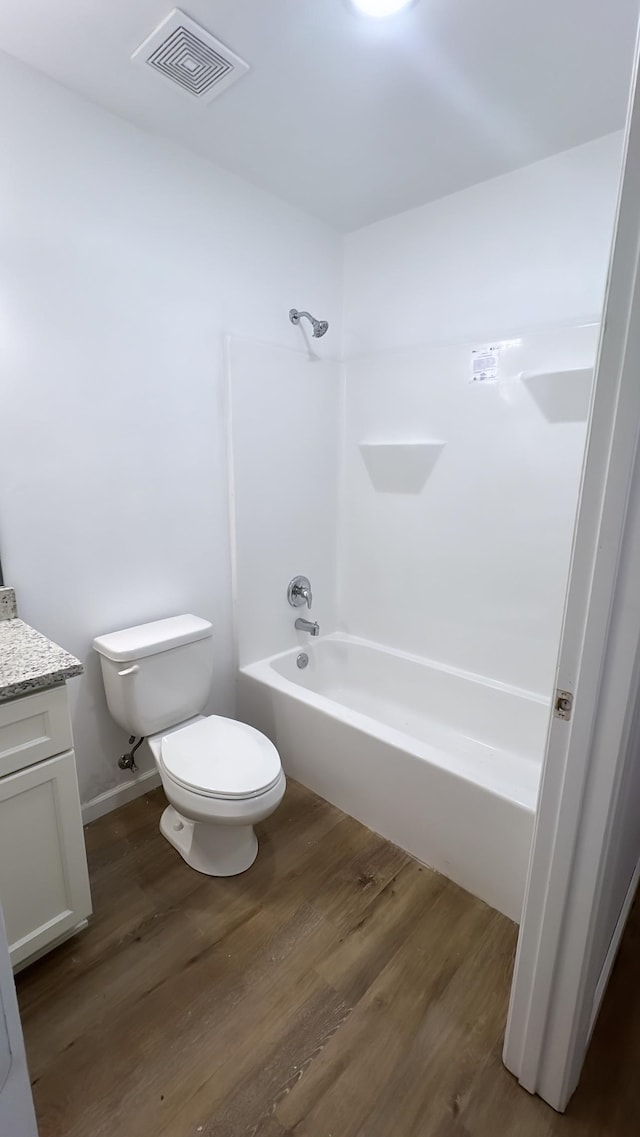 full bathroom featuring toilet, bathtub / shower combination, vanity, and hardwood / wood-style floors