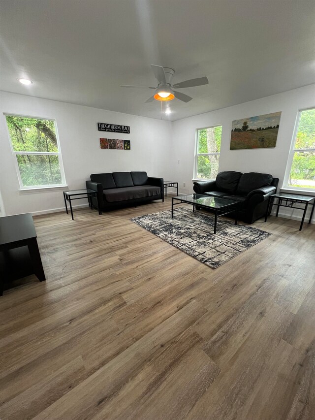 living room featuring hardwood / wood-style flooring, ceiling fan, and plenty of natural light