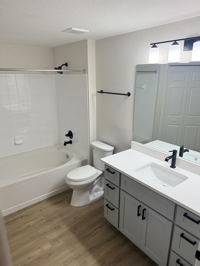 full bathroom with tub / shower combination, hardwood / wood-style floors, vanity, and a textured ceiling