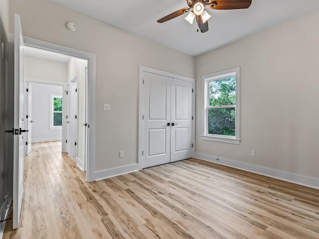 117 Anhinga Trl, Carrabelle, FL 32322 - unfurnished bedroom with light wood finished floors, multiple windows, a closet, and a ceiling fan