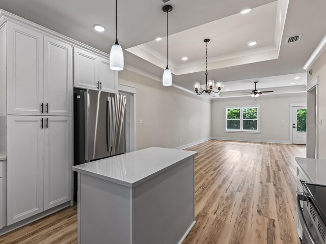 117 Anhinga Trl, Carrabelle, FL 32322 - kitchen with appliances with stainless steel finishes, a raised ceiling, open floor plan, a chandelier, and crown molding
