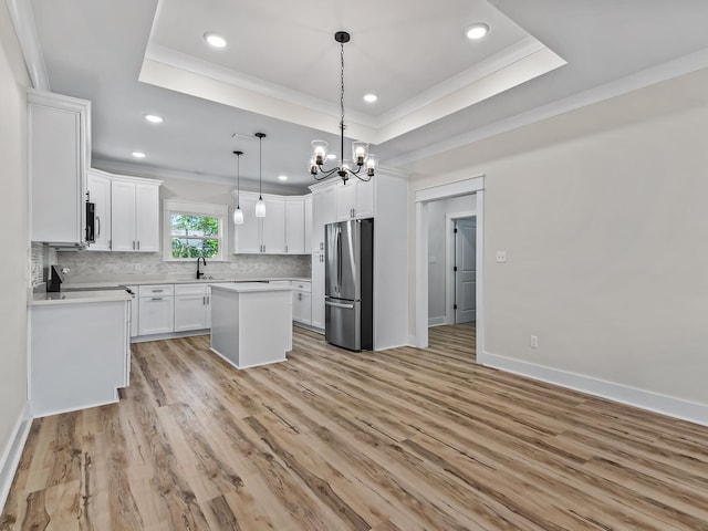 117 Anhinga Trl, Carrabelle, FL 32322 - kitchen featuring stainless steel appliances, crown molding, a raised ceiling, recessed lighting, and a chandelier