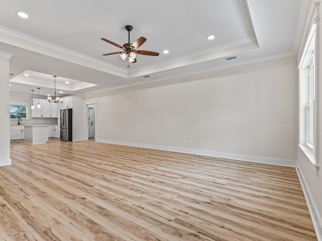 117 Anhinga Trl, Carrabelle, FL 32322 - unfurnished living room featuring a tray ceiling, recessed lighting, light wood-style flooring, ornamental molding, and ceiling fan