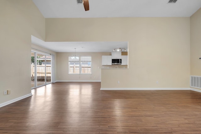1790 Newman Ln, Tallahassee, FL 32312 - unfurnished living room featuring a chandelier, a ceiling fan, dark wood-style flooring, and baseboards
