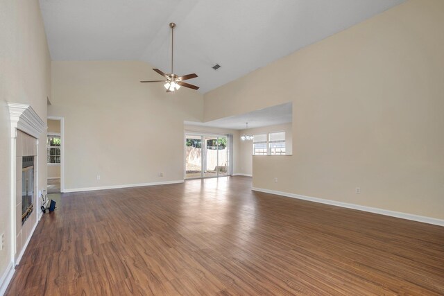 1790 Newman Ln, Tallahassee, FL 32312 - unfurnished living room featuring ceiling fan, wood finished floors, baseboards, high vaulted ceiling, and a chandelier