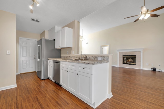 1790 Newman Ln, Tallahassee, FL 32312 - kitchen with stainless steel appliances, a sink, dark wood-style flooring, open floor plan, and white cabinetry