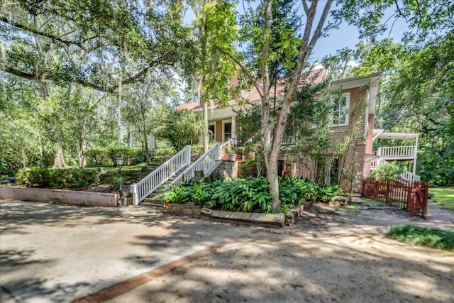 727 Miccosukee Rd -, Unit Tallahassee, FL 32308 - view of property hidden behind natural elements featuring stairway and covered porch