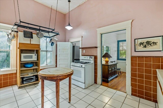 727 Miccosukee Rd -, Unit Tallahassee, FL 32308 - kitchen with white appliances, light tile patterned flooring, plenty of natural light, a high ceiling, and wainscoting