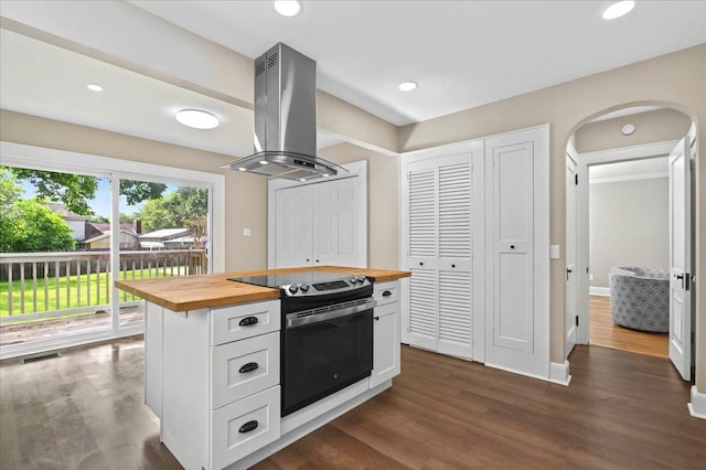 kitchen featuring dark wood finished floors, white cabinetry, island range hood, electric range oven, and wood counters