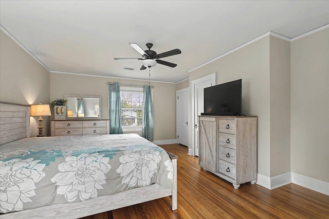 bedroom featuring baseboards, crown molding, wood finished floors, and visible vents