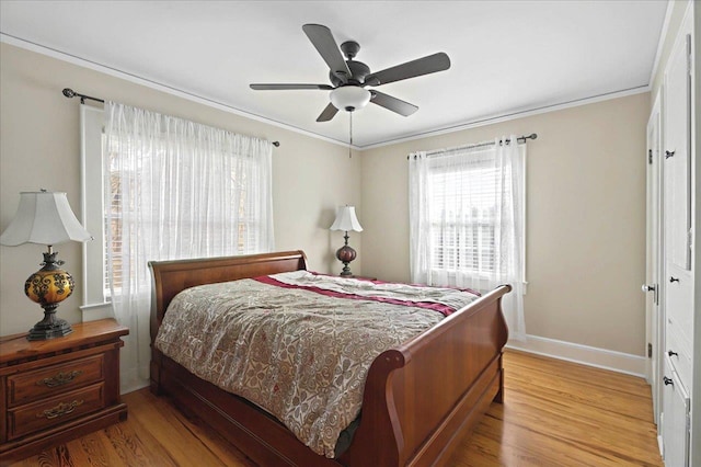 bedroom with baseboards, ornamental molding, and light wood-style floors