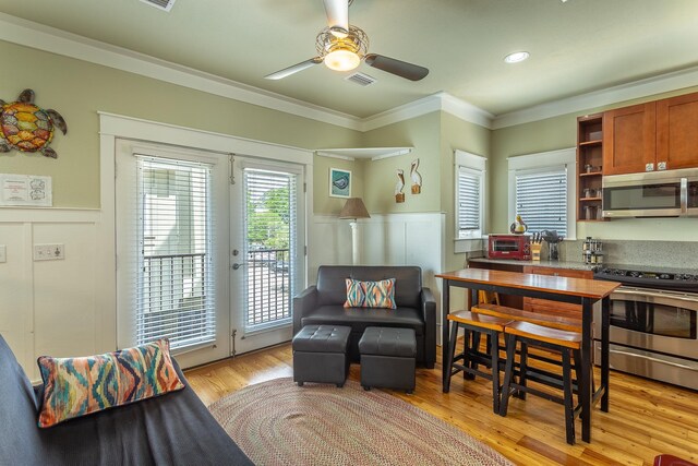 377 Pirates Landing Dr, Carrabelle, FL 32320 - interior space with ornamental molding, visible vents, light wood-style flooring, a ceiling fan, and wainscoting