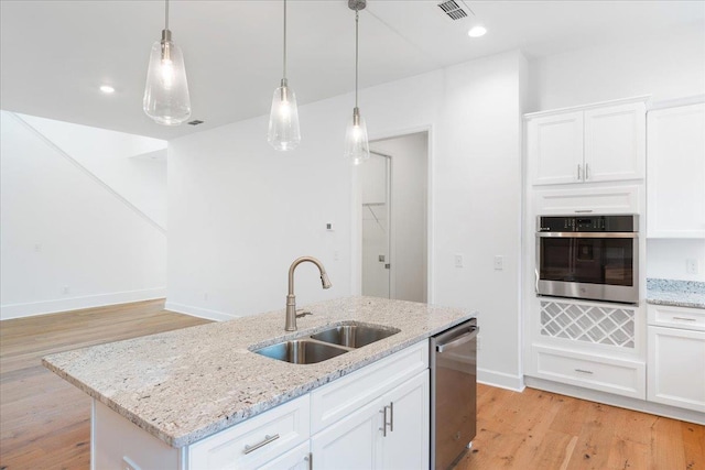 kitchen with a center island with sink, white cabinets, sink, light hardwood / wood-style flooring, and appliances with stainless steel finishes