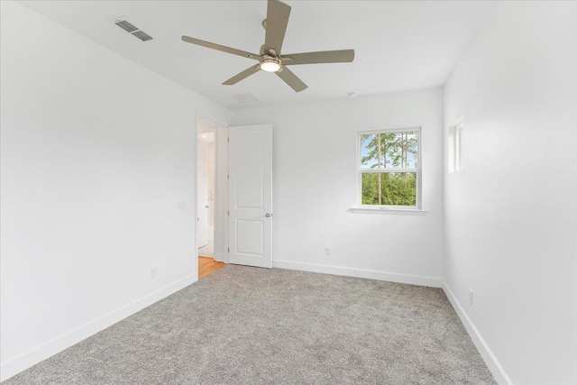 empty room featuring ceiling fan and light carpet